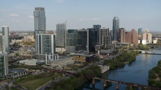 DX0002_104_002 - 5.7K aerial stock footage slowly flying by tall skyscrapers and bridges spanning Lady Bird Lake, Downtown Austin, Texas