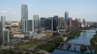 DX0002_104_006 - 5.7K stock footage aerial video tall skyscrapers seen while flying by bridges over Lady Bird Lake, Downtown Austin, Texas