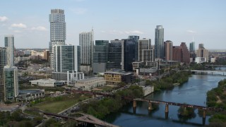 DX0002_104_007 - 5.7K aerial stock footage reverse view of tall skyscrapers and bridges over Lady Bird Lake, Downtown Austin, Texas