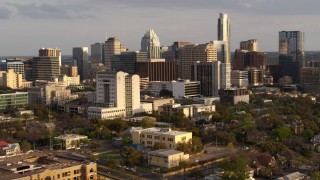 DX0002_104_038 - 5.7K aerial stock footage of a courthouse and office buildings near skyscrapers at sunset in Downtown Austin, Texas