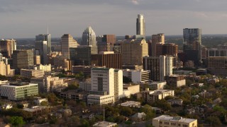 DX0002_104_040 - 5.7K aerial stock footage reverse view and flyby of a courthouse and office buildings near skyscrapers at sunset in Downtown Austin, Texas