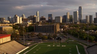 DX0002_105_007 - 5.7K aerial stock footage fly over football stadium, approach office buildings and skyscrapers at sunset in Downtown Austin, Texas