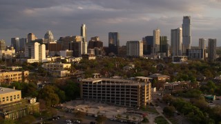 DX0002_105_012 - 5.7K aerial stock footage descend while focused on office buildings and skyscrapers at sunset, reveal parking garage in Downtown Austin, Texas
