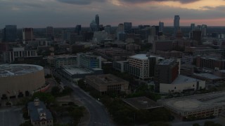 DX0002_105_018 - 5.7K aerial stock footage reverse view of hospital, skyscrapers and capitol dome at sunset in Downtown Austin, Texas