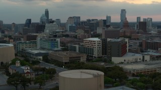 DX0002_105_021 - 5.7K aerial stock footage ascend for view of hospital, skyscrapers and capitol dome at sunset in Downtown Austin, Texas
