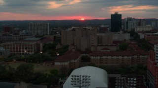 DX0002_105_029 - 5.7K aerial stock footage of flying by the university campus with setting sun in distance, Austin, Texas