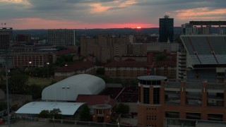 DX0002_105_030 - 5.7K aerial stock footage of descending by the university campus with setting sun in distance, Austin, Texas