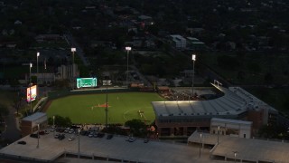 DX0002_105_038 - 5.7K aerial stock footage of a baseball game at a stadium at the University of Texas at twilight, Austin, Texas