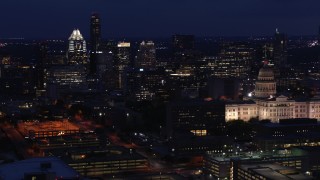 DX0002_106_002 - 5.7K stock footage aerial video flyby office buildings and skyscrapers at night, reveal capitol in Downtown Austin, Texas