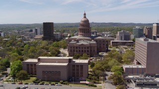 DX0002_107_017 - 5.7K aerial stock footage descend by library and orbit the Texas State Capitol dome and grounds in Downtown Austin, Texas