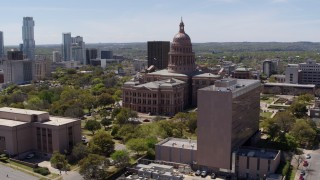DX0002_107_023 - 5.7K aerial stock footage of fly away from the Texas State Capitol, descend near government office building in Downtown Austin, Texas