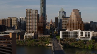 DX0002_109_029 - 5.7K aerial stock footage of the Texas State Capitol seen between skyscrapers in Downtown Austin, Texas