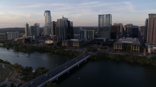 DX0002_110_011 - 5.7K aerial stock footage of the city's skyline, and bridge spanning Lady Bird Lake at sunset, Downtown Austin, Texas