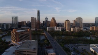 DX0002_110_013 - 5.7K aerial stock footage of skyline across bridge and Lady Bird Lake at sunset in Downtown Austin, Texas