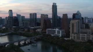 DX0002_110_023 - 5.7K stock footage aerial video of a reverse view of Austonian and skyline from Lady Bird Lake at twilight in Downtown Austin, Texas