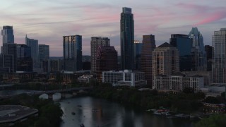 DX0002_110_028 - 5.7K aerial stock footage focus on The Austonian in city skyline during allow approach from Lady Bird Lake at twilight in Downtown Austin, Texas