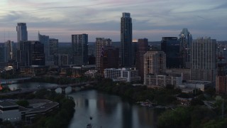 DX0002_110_031 - 5.7K aerial stock footage of The Austonian and city skyline seen from Lady Bird Lake at twilight in Downtown Austin, Texas