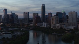 DX0002_110_034 - 5.7K aerial stock footage of tall Austonian and city skyline seen during pass over Lady Bird Lake at twilight in Downtown Austin, Texas