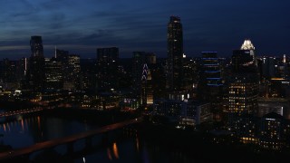DX0002_111_003 - 5.7K aerial stock footage approach Austonian and waterfront skyline from Lady Bird Lake at twilight in Downtown Austin, Texas