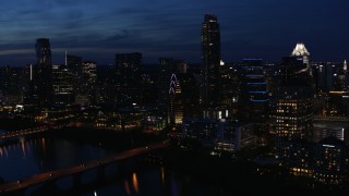 DX0002_111_004 - 5.7K aerial stock footage fly away from Austonian and waterfront skyline, seen from Lady Bird Lake at twilight in Downtown Austin, Texas