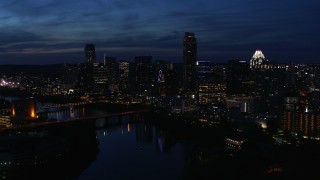 DX0002_111_005 - 5.7K aerial stock footage a reverse view of waterfront skyline, seen from Lady Bird Lake at twilight in Downtown Austin, Texas
