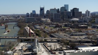 DX0002_113_008 - 5.7K aerial stock footage a view of city's skyline while flying away from traffic on bridge over the river, Downtown Nashville, Tennessee