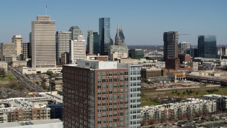 DX0002_113_023 - 5.7K aerial stock footage descend by office building, skyline in background, Downtown Nashville, Tennessee