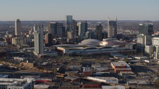 DX0002_114_017 - 5.7K aerial stock footage of flying by the convention center and skyline before descent in Downtown Nashville, Tennessee