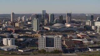 DX0002_114_020 - 5.7K aerial stock footage ascend and flyby the city skyline behind the convention center in Downtown Nashville, Tennessee