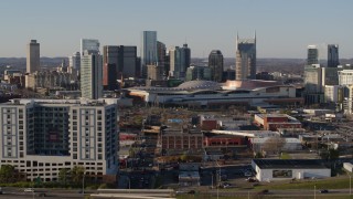 DX0002_114_022 - 5.7K aerial stock footage fly away from the city skyline behind the convention center, descend by apartments in Downtown Nashville, Tennessee