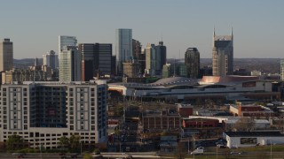 DX0002_114_038 - 5.7K aerial stock footage ascend past apartment complex, focus on city's tall skyline by convention center in Downtown Nashville, Tennessee