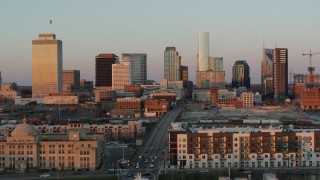 DX0002_115_005 - 5.7K aerial stock footage approach Church Street, ascend for view of city's skyline at sunset in Downtown Nashville, Tennessee