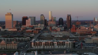 DX0002_115_009 - 5.7K aerial stock footage descend near apartments, focus on city's skyline at sunset in Downtown Nashville, Tennessee