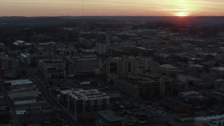 DX0002_115_015 - 5.7K aerial stock footage ascend and fly away from hospital with view of setting sun, Nashville, Tennessee