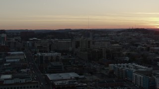 DX0002_115_016 - 5.7K aerial stock footage descend near a hospital complex with view of setting sun, Nashville, Tennessee