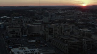 DX0002_115_017 - 5.7K aerial stock footage approach hospital complex and ascend with view of setting sun, Nashville, Tennessee
