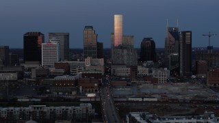 DX0002_115_021 - 5.7K aerial stock footage of passing by Church Street and the city's skyline at twilight in Downtown Nashville, Tennessee