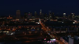 DX0002_115_051 - 5.7K aerial stock footage following Church Street toward the city skyline at night, Downtown Nashville, Tennessee