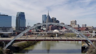 DX0002_116_004 - 5.7K aerial stock footage of tall skyscrapers seen from a bridge spanning the river in Downtown Nashville, Tennessee