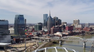 DX0002_116_007 - 5.7K aerial stock footage of a reverse view of the AT&T Building and a bridge over the river in Downtown Nashville, Tennessee