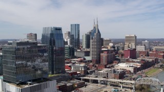 DX0002_116_011 - 5.7K aerial stock footage of flying by skyscrapers and reveal an office high-rise in Downtown Nashville, Tennessee