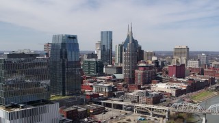 DX0002_116_015 - 5.7K aerial stock footage of flying by skyscrapers and reveal an office high-rise in Downtown Nashville, Tennessee