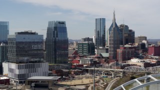 DX0002_116_031 - 5.7K aerial stock footage descend and orbit office high-rise and skyscrapers, seen from the river in Downtown Nashville, Tennessee