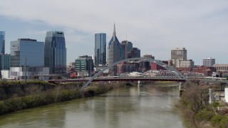 DX0002_116_033 - 5.7K aerial stock footage flyby and approach bridge on Cumberland River near skyscrapers in Downtown Nashville, Tennessee