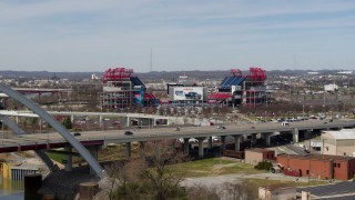 DX0002_116_045 - 5.7K aerial stock footage reverse view of Nissan Stadium behind the bridge in Nashville, Tennessee