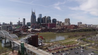 DX0002_117_005 - 5.7K aerial stock footage fly toward the city's riverfront skyscrapers from the pedestrian bridge, Downtown Nashville, Tennessee