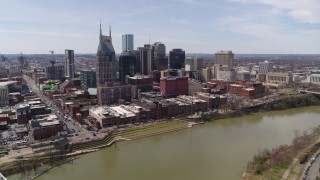 DX0002_117_006 - 5.7K aerial stock footage reverse view of the city's riverfront skyscrapers by the Cumberland River, Downtown Nashville, Tennessee