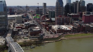 DX0002_117_032 - 5.7K aerial stock footage ascend while approaching Broadway across the Cumberland River, Downtown Nashville, Tennessee