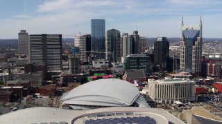 DX0002_117_034 - 5.7K aerial stock footage of flying by the city's skyline behind the arena, Downtown Nashville, Tennessee