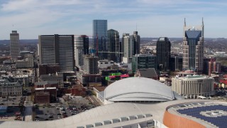 DX0002_117_035 - 5.7K aerial stock footage of a stationary view of the city's skyline behind the arena, Downtown Nashville, Tennessee